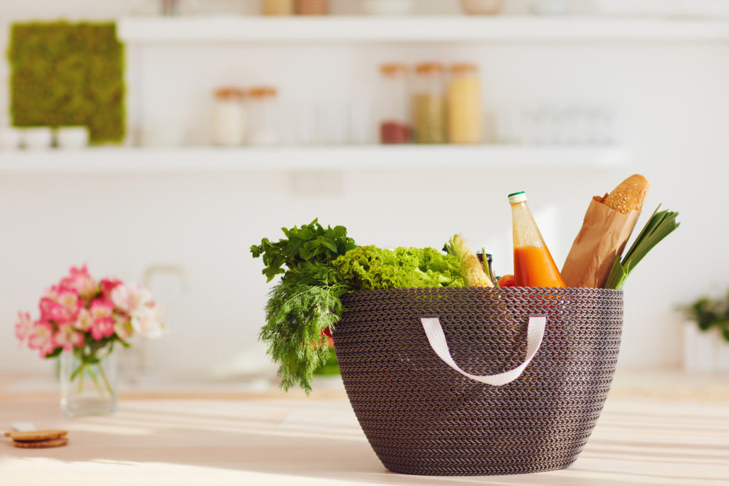 shopping bag full of fresh food on kitchen desk