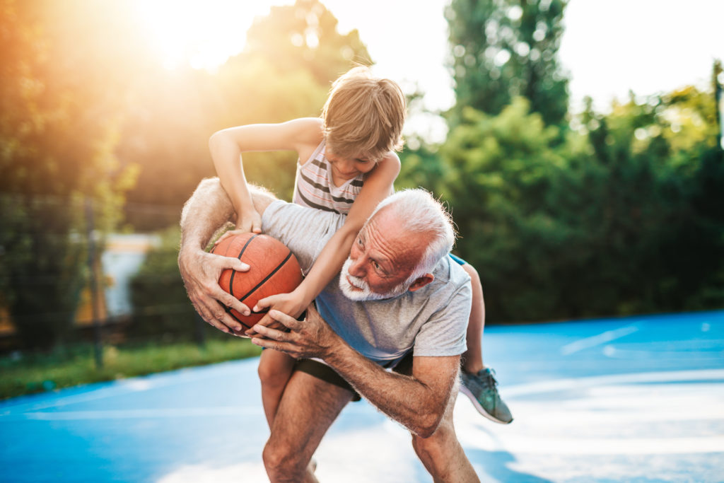 Grandfather and his grandson playing basketball.